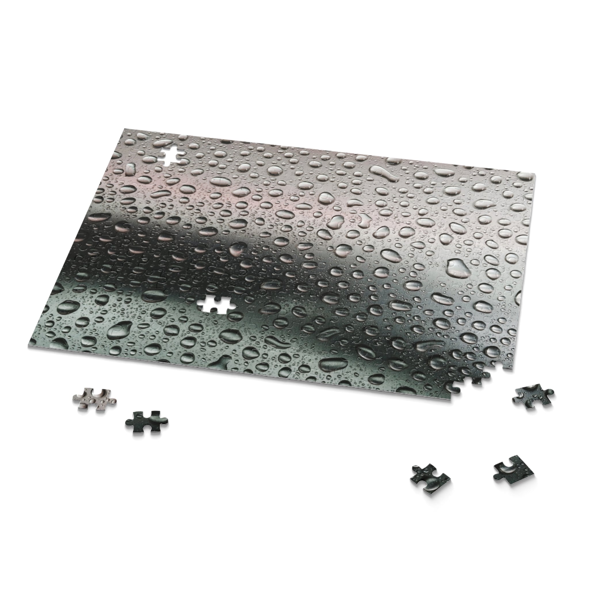 Jigsaw puzzle with water droplets on a transparent sheet and scattered pieces on a white background