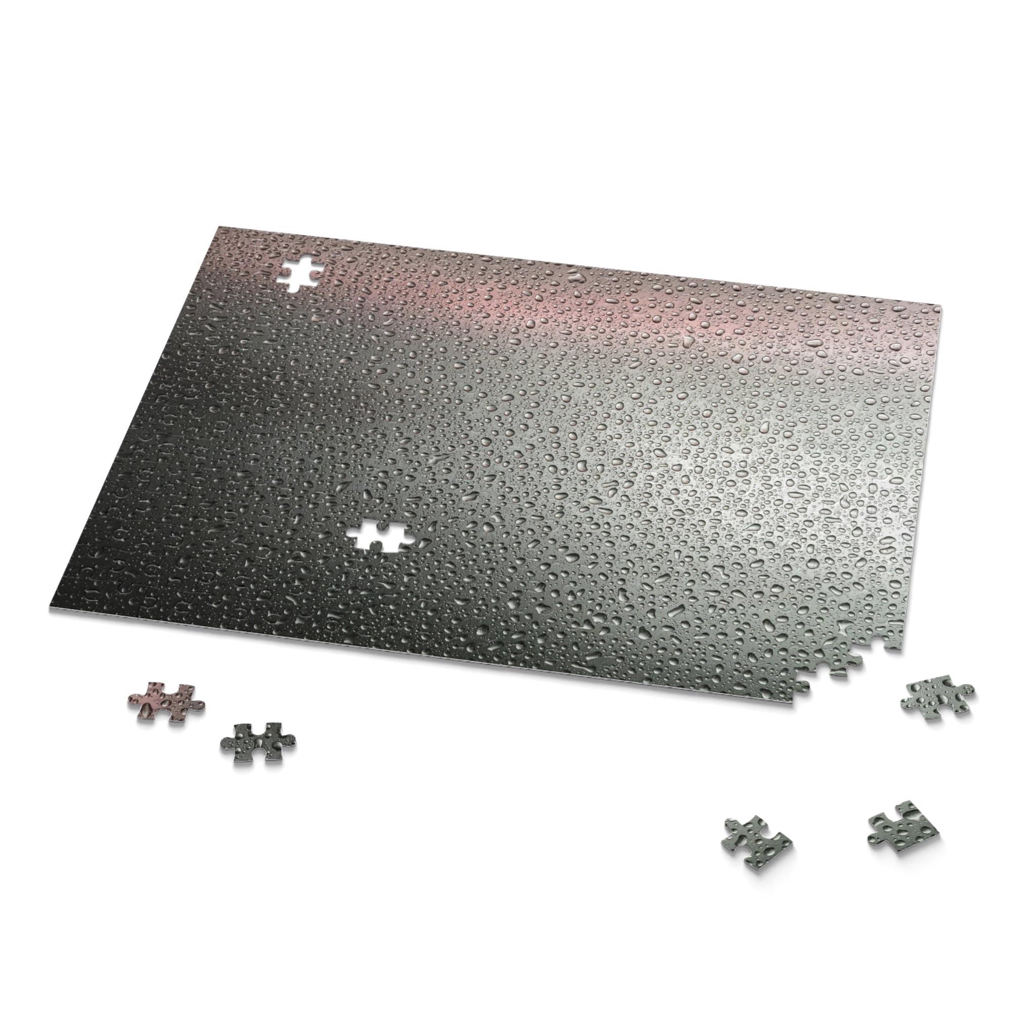 Jigsaw puzzle with a gradient black to silver puzzle mat and scattered pieces on a white background