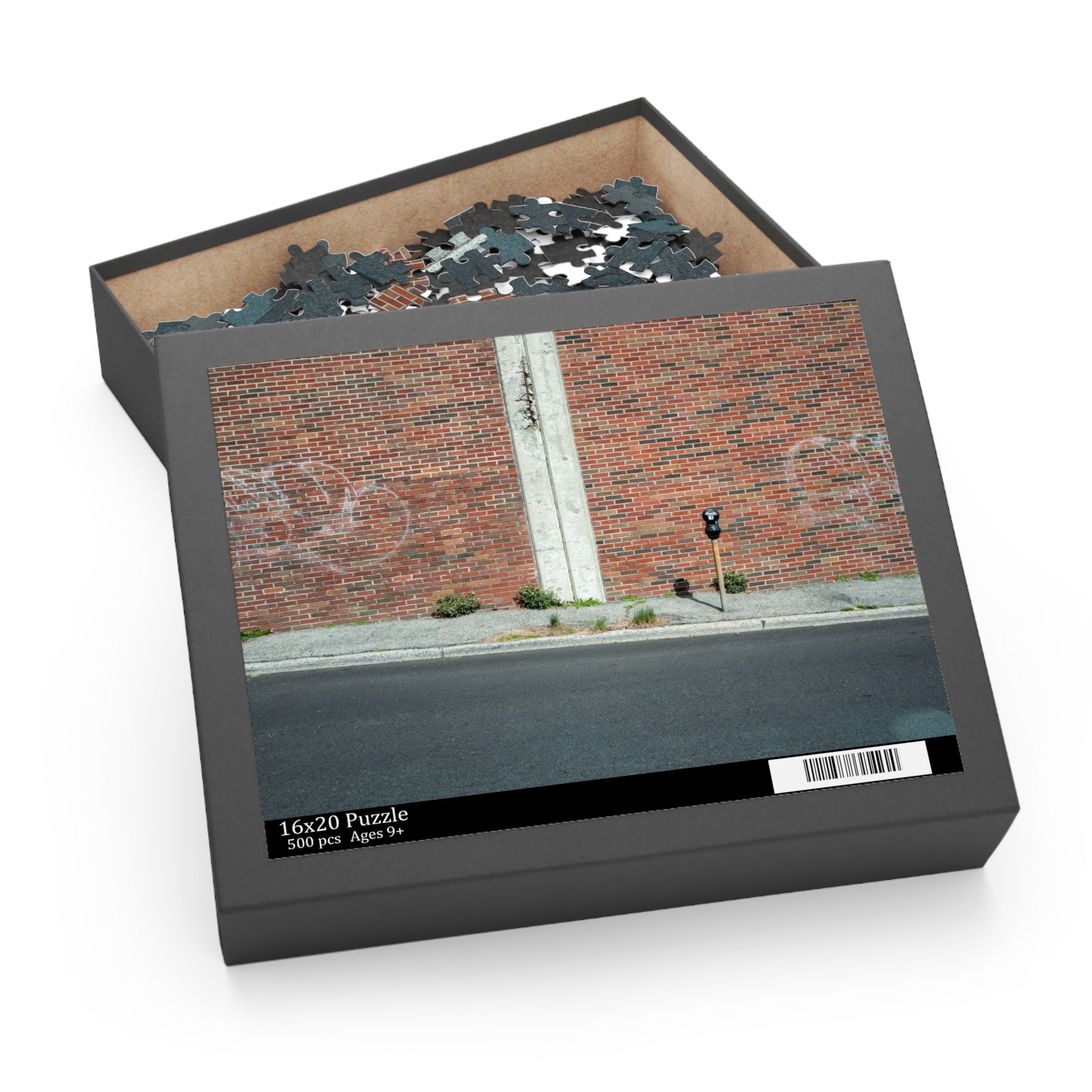Jigsaw puzzle box with a brick wall and street scene on the lid, containing puzzle pieces inside.