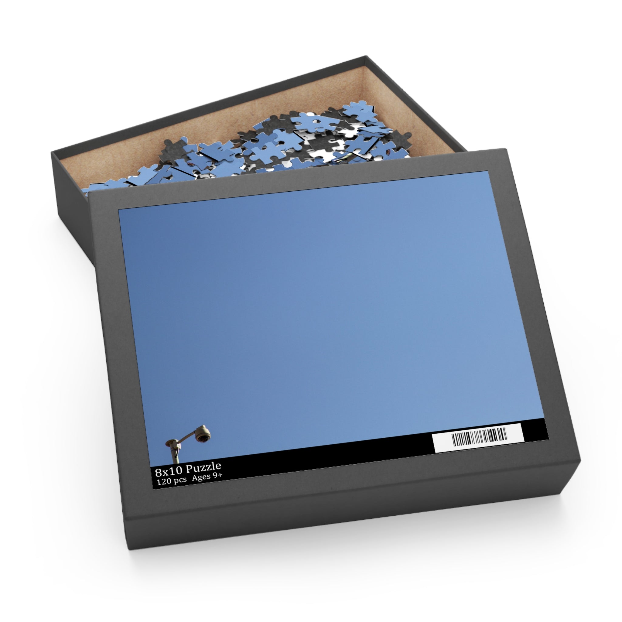 Jigsaw puzzle in an open box with a blue cover on a white background