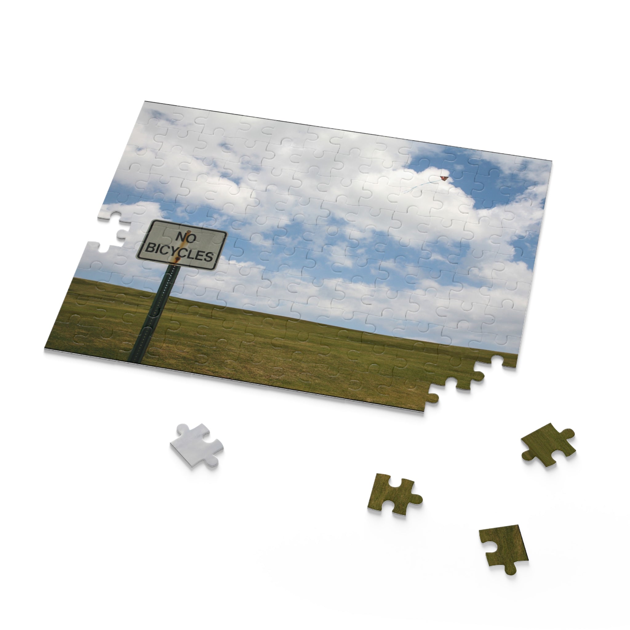 Jigsaw puzzle with a 'No Bicycles' sign and landscape on a white background