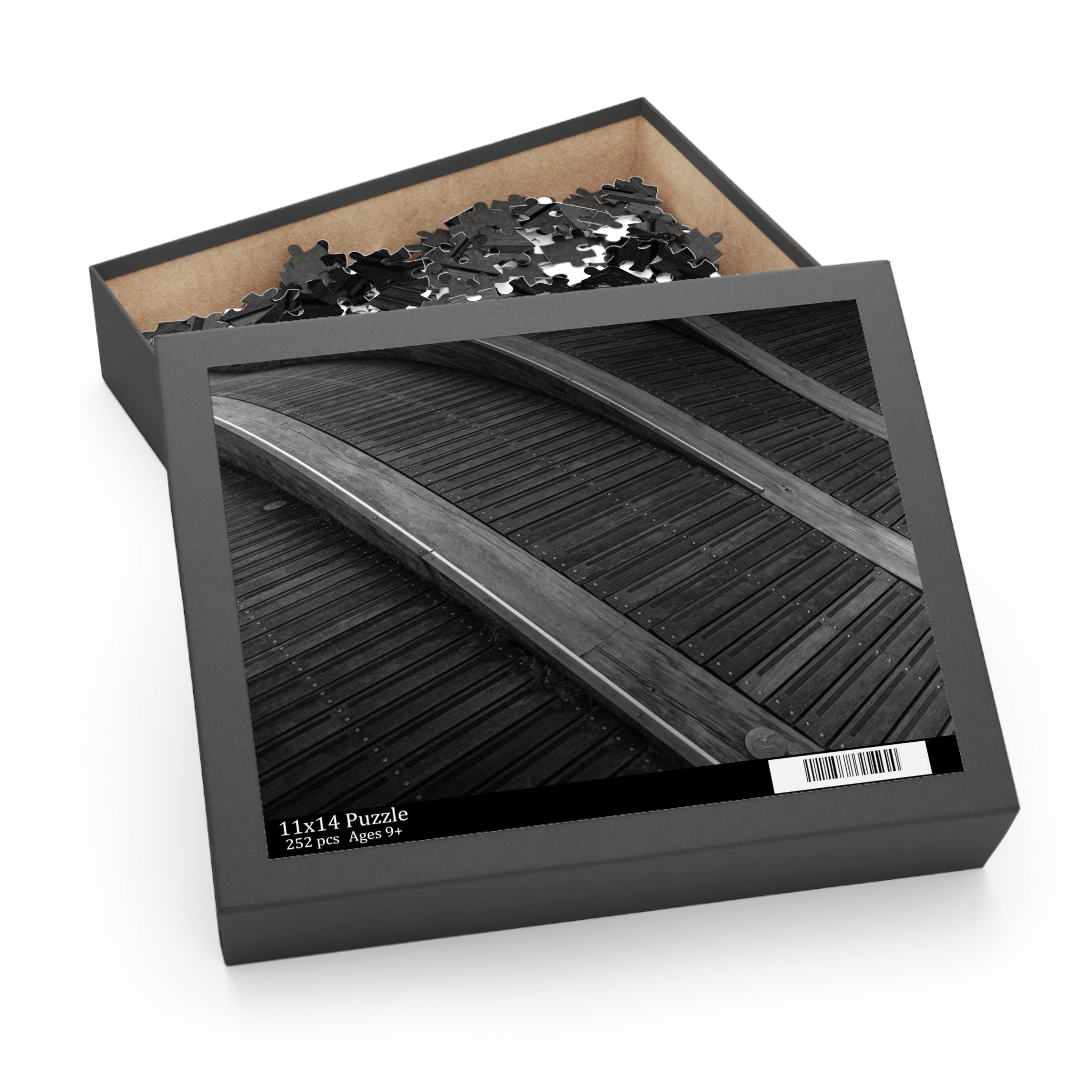 Jigsaw puzzle in a black box with a lid open, showing some pieces.