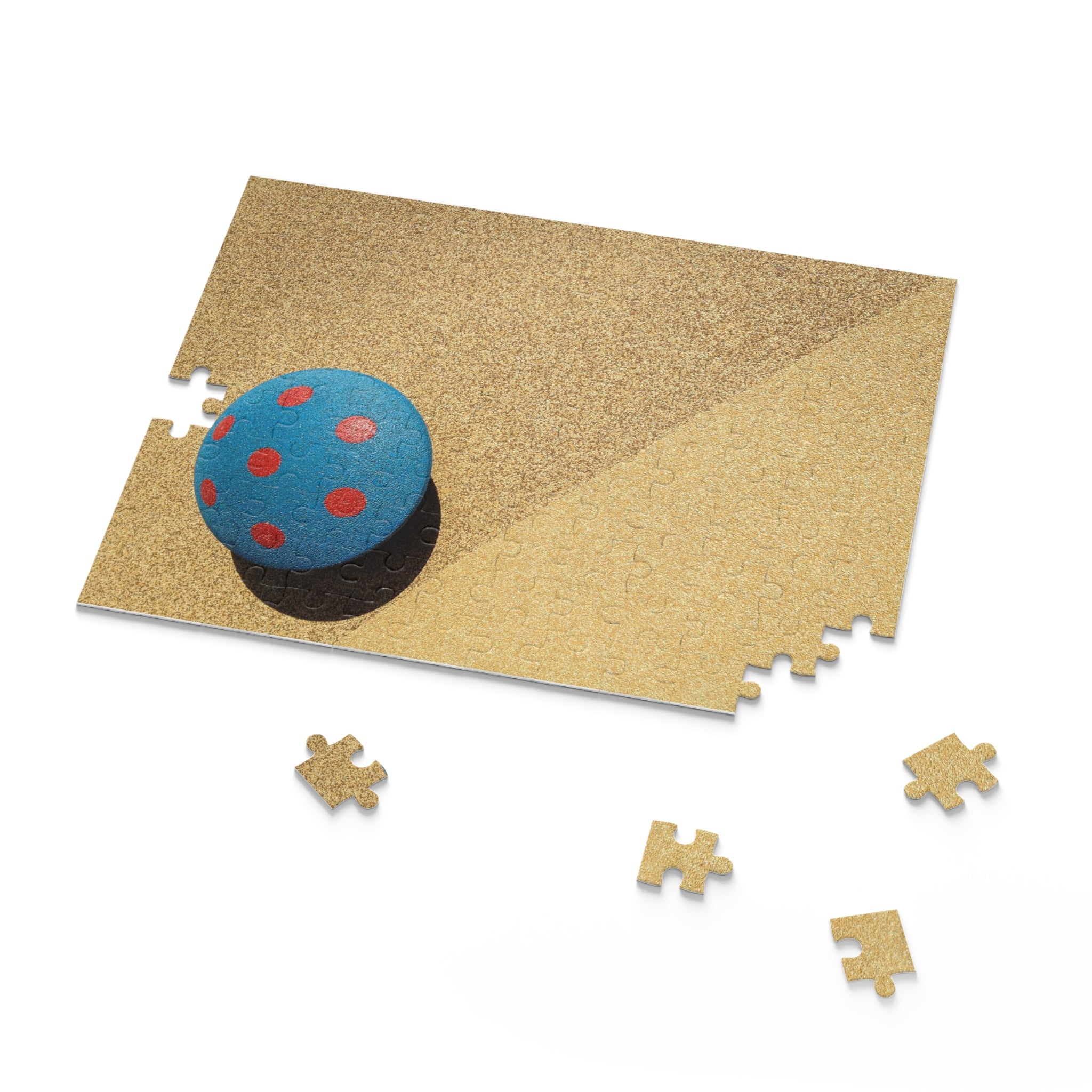 Jigsaw puzzle with a blue and red sphere on a beige mat, with missing pieces.