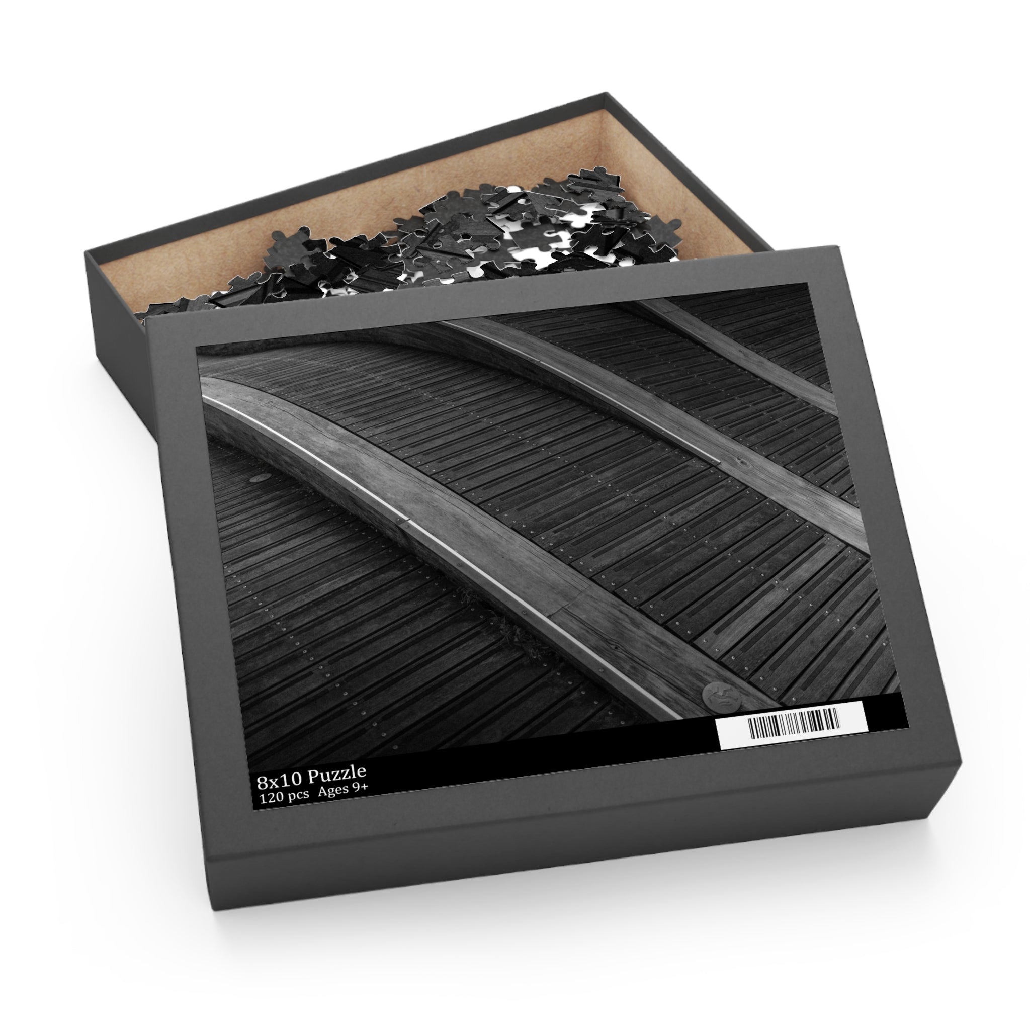 Jigsaw puzzle in a black box with a wooden base on a white background