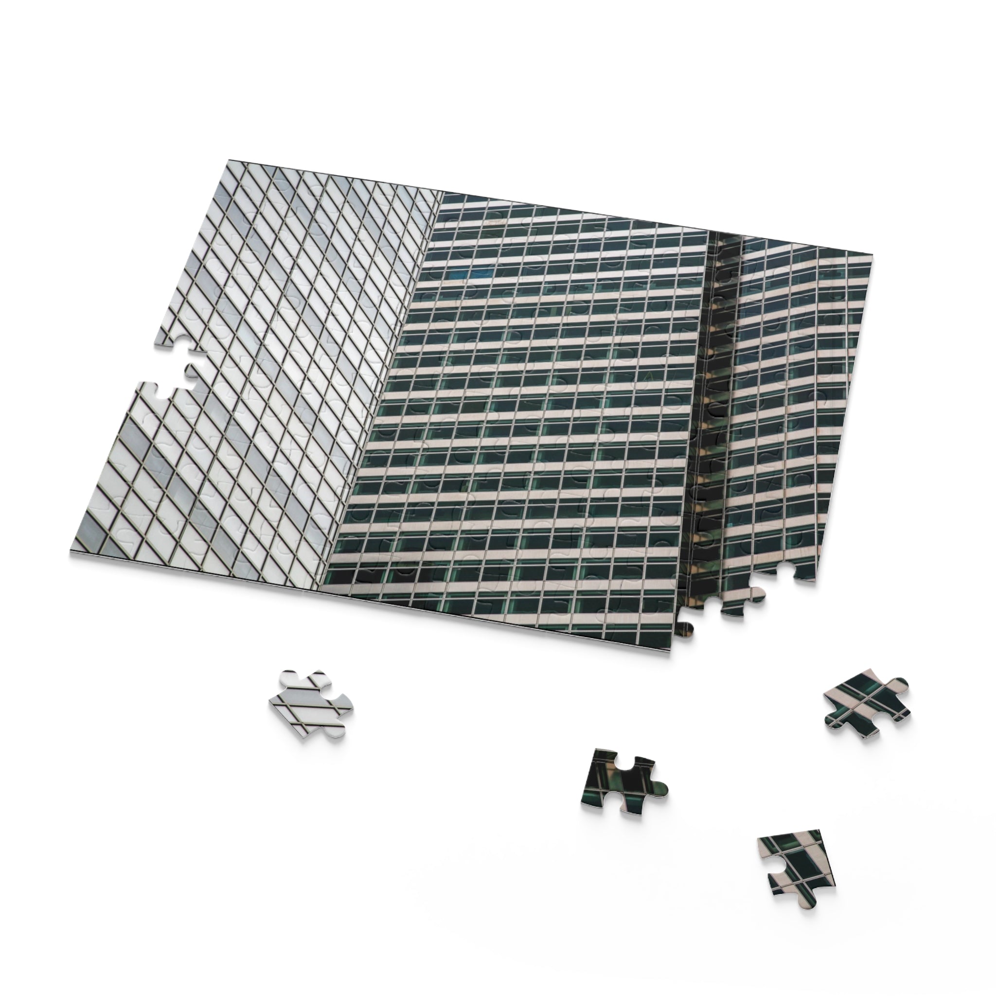 Model of a building with glass facade and metal base, surrounded by puzzle pieces.